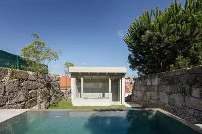 a swimming pool next to a stone wall with a pavilion at L'Olivier 23 - 2 apartments in a recently renovated Guesthouse in Porto