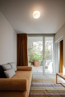 a living room with a couch and a sliding glass door at L'Olivier 23 - 2 apartments in a recently renovated Guesthouse in Porto