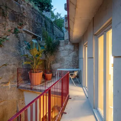 a balcony with a red fence and a plant at L'Olivier 23 - 2 apartments in a recently renovated Guesthouse in Porto