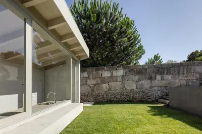 a house with a stone wall and a yard at L'Olivier 23 - 2 apartments in a recently renovated Guesthouse in Porto