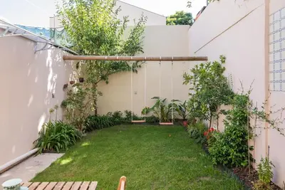 a small backyard with a yard with grass and trees at Gardeny Porto in Porto