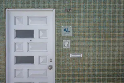 a door on a brick wall with aaa sign on it at Gardeny Porto in Porto