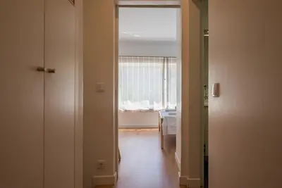 a hallway with a window and a room with a table at Gardeny Porto in Porto