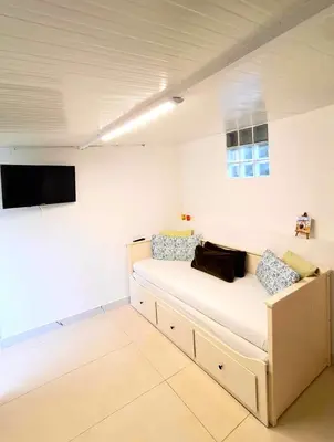a room with a couch and a tv on the wall at Bela Houses - Porto Center Garden - 3 in Porto