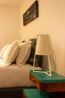a bed with pillows and a lamp on a table at ORM Santana Apartment in Porto