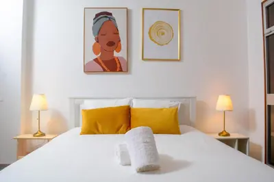 a bedroom with a white bed with two lamps at Travel & Live Marques Apartments in Porto
