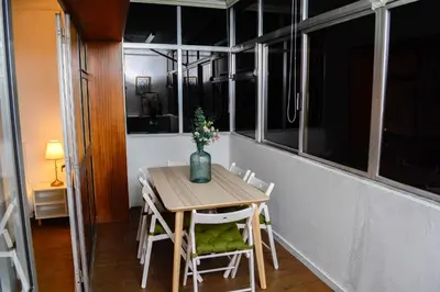 a table with chairs and a vase with flowers on it at Travel & Live Marques Apartments in Porto