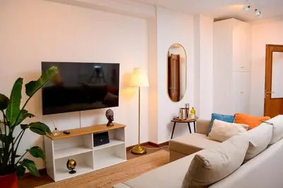 a living room with a white couch and a tv at Travel & Live Marques Apartments in Porto