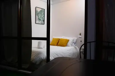 a bedroom with a bed with yellow pillows and a mirror at Travel & Live Marques Apartments in Porto