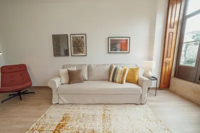 a living room with a white couch and a red chair at Modern Bonfim by Hosty in Porto
