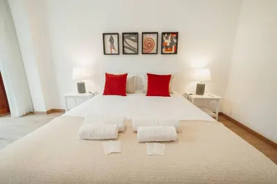 a bedroom with a large bed with red pillows at Modern Bonfim by Hosty in Porto