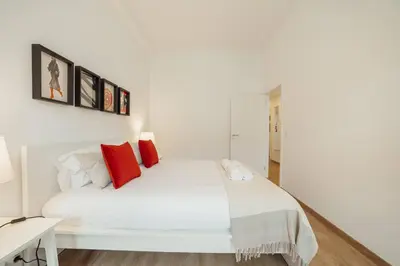 a bedroom with a white bed with red pillows at Modern Bonfim by Hosty in Porto