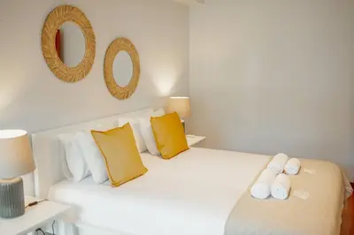 a bedroom with a white bed with yellow pillows at Bonfim Vintage by Hosty in Porto