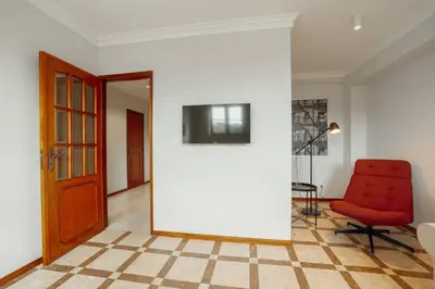 a room with a red chair and a white wall at Bonfim Vintage by Hosty in Porto