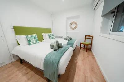a bedroom with two beds and a couch at Douro Garden - Authentic Portuguese Guesthouse in Vila Nova de Gaia