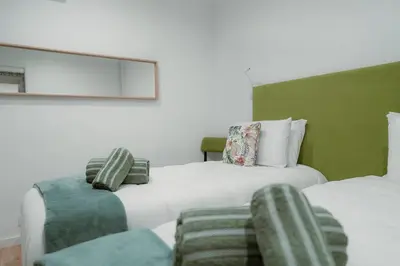 a bedroom with two beds and a chair at Douro Garden - Authentic Portuguese Guesthouse in Vila Nova de Gaia