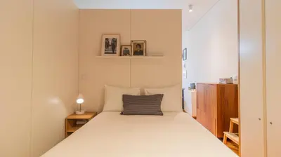 a dining room table with chairs and a book shelf at Bolhão Charming Apartment by LovelyStay in Porto
