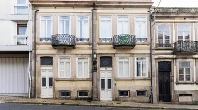 an old building with white doors and windows at Bolhão Charming Apartment by LovelyStay in Porto