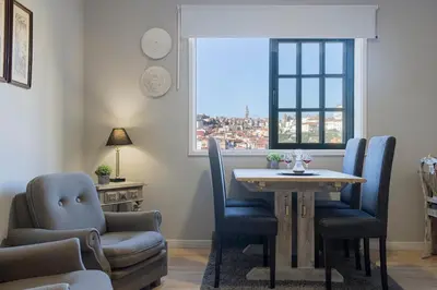 a dining room with a table and chairs and a window at MyRiverPlace N 1 River View Porto apartments in Vila Nova de Gaia