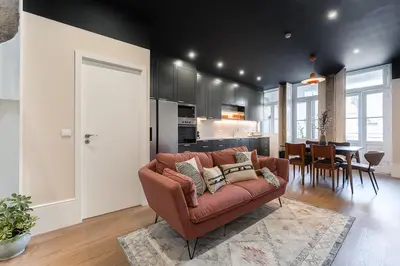 a living room with a couch and a kitchen at L'Atelier by Upperground in Porto