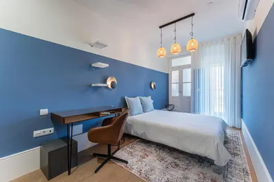a blue bedroom with a bed and a desk at L'Atelier by Upperground in Porto