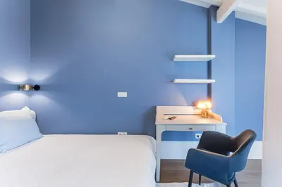 a bedroom with a bed and a desk and a chair at L'Atelier by Upperground in Porto
