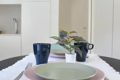 a table with a plate and two cups and a plant at Classy Urban Life Studio Oporto in Porto