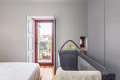 a bedroom with a bed and an open door at Almada 505 - Premium Flat in Porto