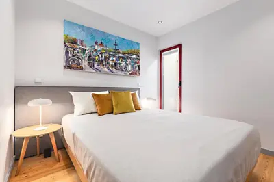 a white bedroom with a large white bed with yellow pillows at Almada 505 - Premium Flat in Porto