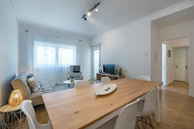 a living room with a large wooden table and chairs at Oliveira Monteiro Flat in Porto
