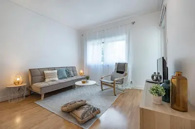 a living room with a couch and a tv at Oliveira Monteiro Flat in Porto