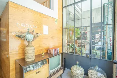 a room with a television and a vase with flowers at FLORES 36 by YoursPorto in Porto
