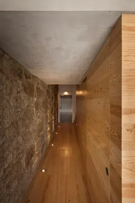 a hallway with wooden floors and a stone wall at FLORES 36 by YoursPorto in Porto