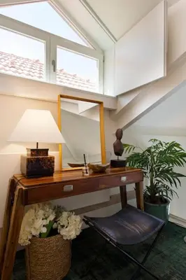 a room with a desk with a lamp and flowers at BOUTiQUE Rentals- LOvPORTO Ribeira historic center in Porto