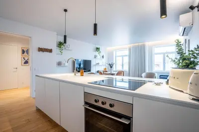 a white kitchen with a sink and a counter at Penthouse with City Views - Almada 551 in Porto