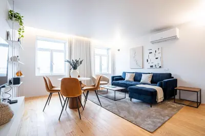 a living room with a blue couch and a table at Penthouse with City Views - Almada 551 in Porto