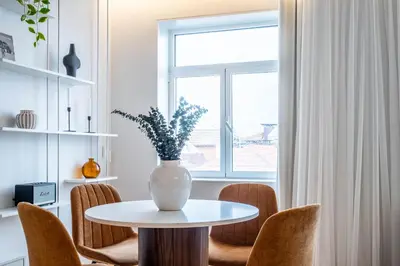a vase on a table with chairs and a window at Penthouse with City Views - Almada 551 in Porto