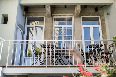 a balcony of a house with tables and chairs at Decanting Porto House in Porto