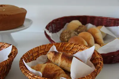 two baskets of bread and pastries on a table at Decanting Porto House in Porto