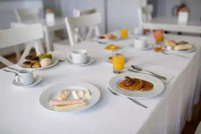 a long white table with plates of food on it at Decanting Porto House in Porto
