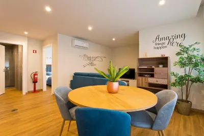 a living room with a table and blue chairs at Aposentus - Sofia's House in Porto