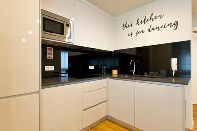 a kitchen with white cabinets and a microwave at Aposentus - Sofia's House in Porto