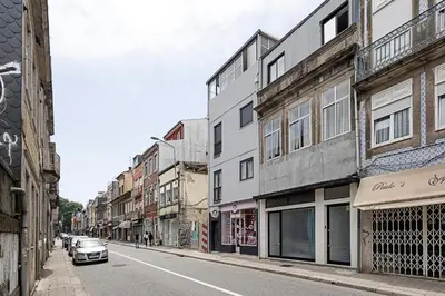 a street with buildings and a car driving down a street at Lovely Flat Marquês in Porto