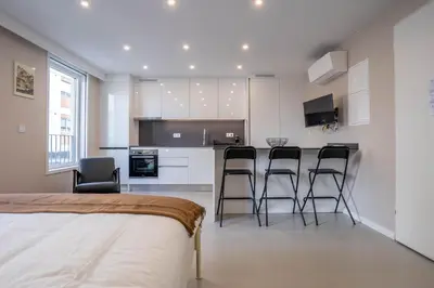 a kitchen with white cabinets and black bar stools at Gaia Retreat by LovelyStay in Vila Nova de Gaia