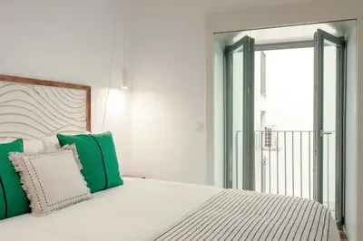 a bedroom with a bed with green and white pillows at Cristelo 1 Bed next to River in Porto