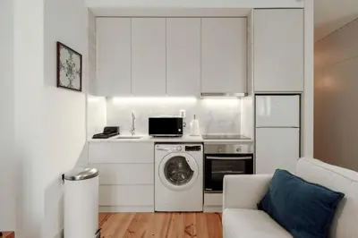a kitchen with a washing machine and a washer at Cristelo 1 Bed next to River in Porto
