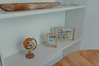 a shelf with three pictures and a globe on it at Cristelo 1 Bed next to River in Porto