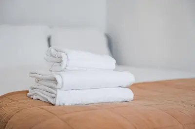 a stack of white towels sitting on top of a table at Catarina's Little Corner by LovelyStay in Porto
