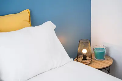 a bed with a pillow and a candle on a table at Catarina's Little Corner by LovelyStay in Porto