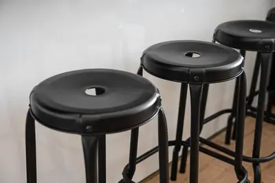 a row of black stools sitting next to a wall at Catarina's Little Corner by LovelyStay in Porto